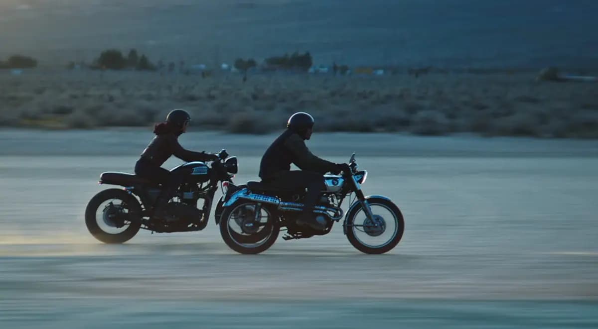 Two people riding motorcycles in the salt flats